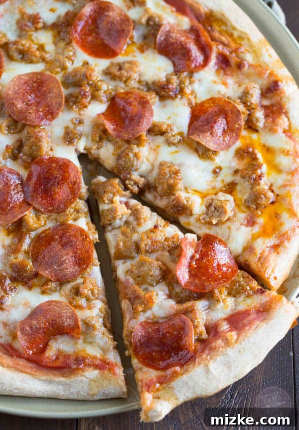 Sausage Pepperoni Inferno 2 A close-up shot of a homemade spicy sausage and pepperoni pizza, fresh out of the oven, with bubbling cheese and crispy edges. It's so much better made at home than getting delivery!