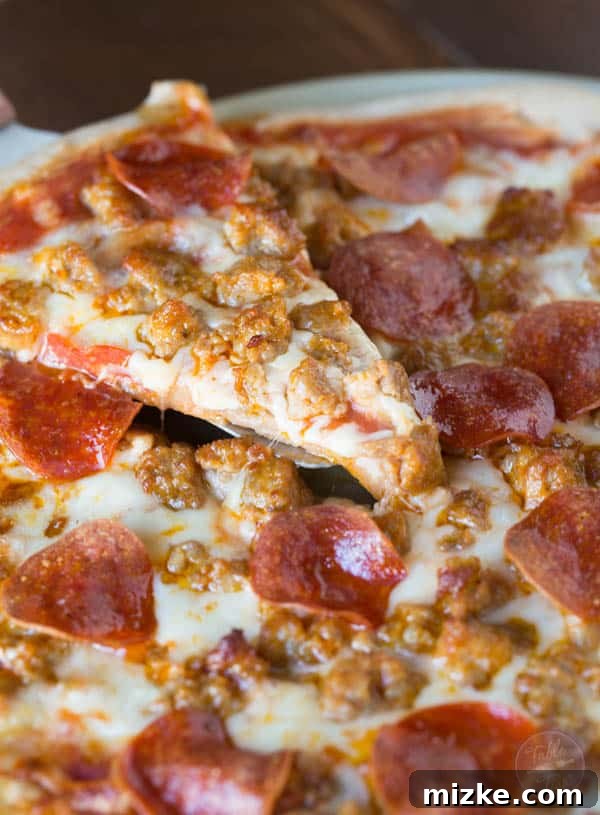 Sausage Pepperoni Inferno 4 A close-up of a pepperoni slice and crumbled spicy sausage on a bed of melted mozzarella cheese, ready to be baked into a delicious homemade pizza. Better than any delivery!