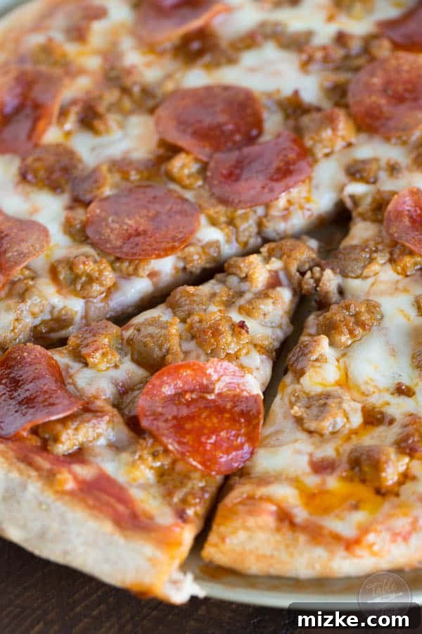 Sausage Pepperoni Inferno 6 A golden-brown pizza crust with perfectly melted cheese and glistening pepperoni, showcasing the deliciousness of a homemade spicy sausage and pepperoni pizza. You'll thank me later for this recipe!