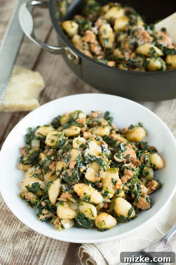 Rustic Spicy Sausage Gnocchi with Spinach and Mushrooms 2 A close-up of a vibrant plate of 15-minute spicy sausage, spinach, and mushroom gnocchi, garnished with fresh herbs, showcasing its rich texture and appealing colors, perfect for a quick and flavorful weeknight dinner.