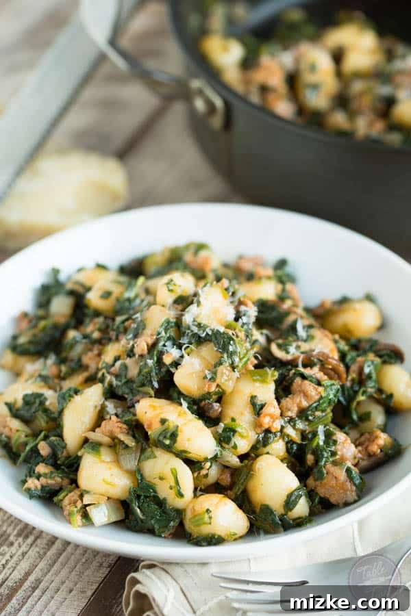 Rustic Spicy Sausage Gnocchi with Spinach and Mushrooms 3 An overhead shot of a skillet filled with freshly cooked spicy sausage, spinach, and mushroom gnocchi, ready to be served, highlighting the steam rising from the hot, savory ingredients.