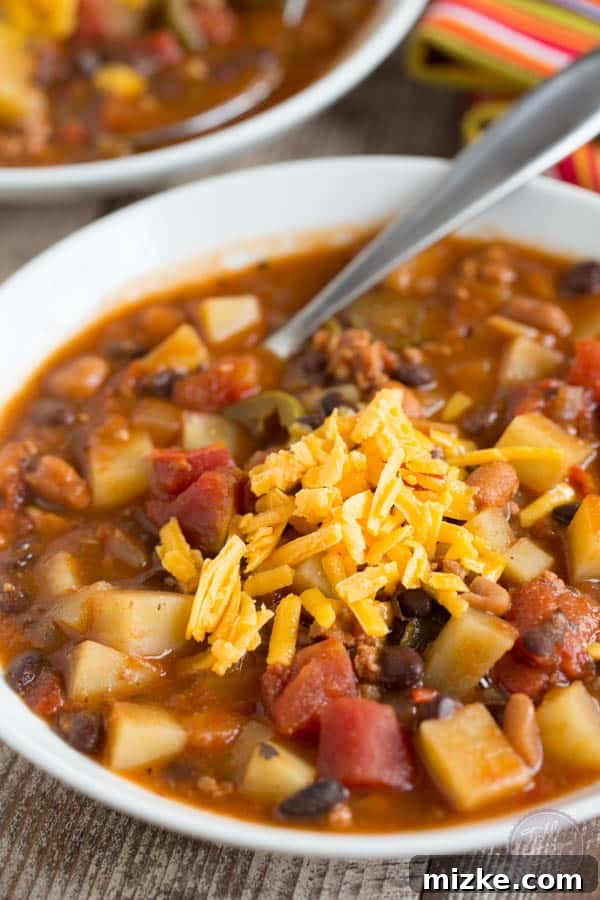 Hearty Chorizo Potato and Double Bean Crockpot Chili 3 Close-up of the chunky texture of the slow cooker chili, showing potatoes, beans, and chorizo.