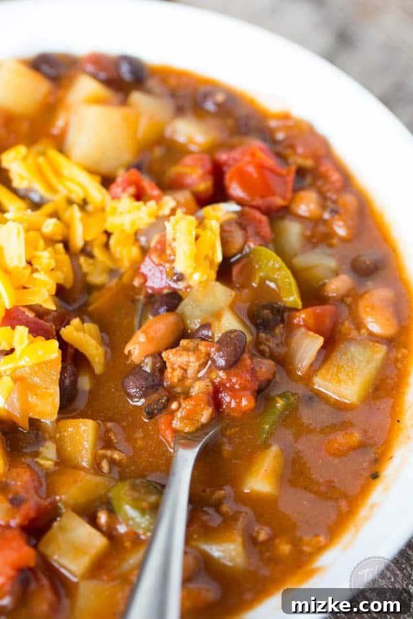 Hearty Chorizo Potato and Double Bean Crockpot Chili 5 Slow cooker chorizo, potato, and two-bean chili simmering, showcasing its rich, dark color and ingredients.