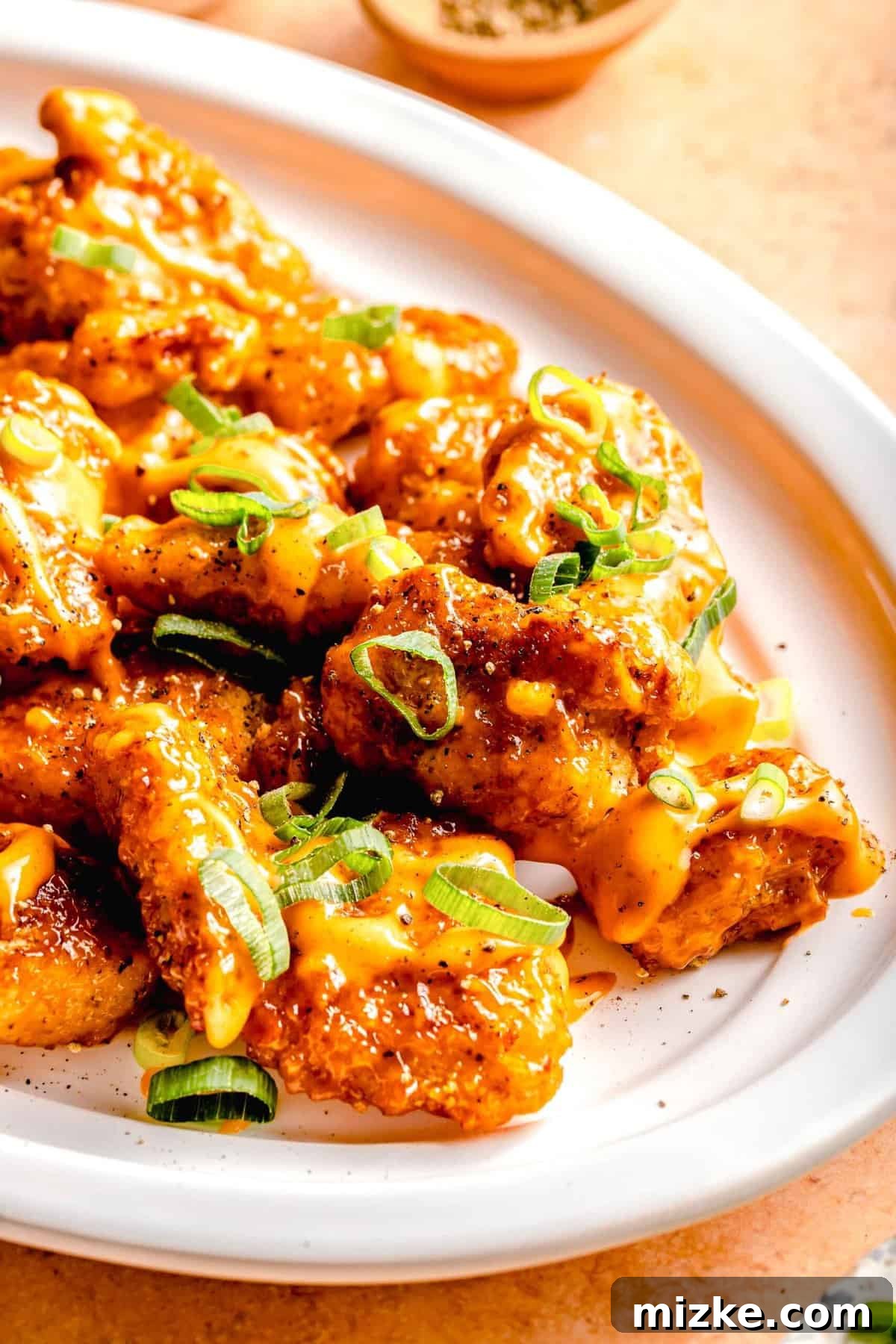 This bang bang chicken dish really lives up to its name. It is A beautifully arranged serving platter piled high with fresh, hot Bang Bang Chicken, garnished with chopped green onions, ready to be enjoyed as a centerpiece dish.