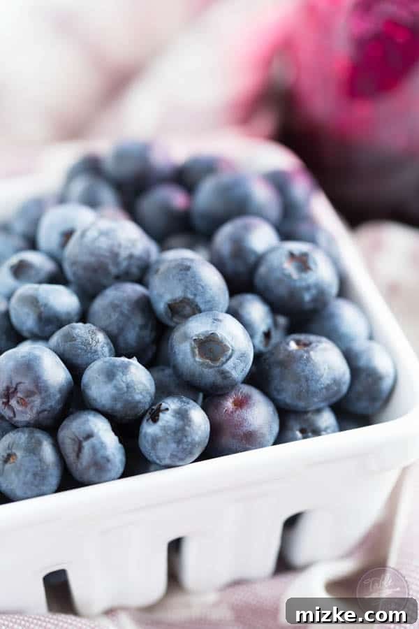 Indigo Bloom Jam 4 A spoonful of blueberry lavender jam being drizzled over creamy Greek yogurt with granola.