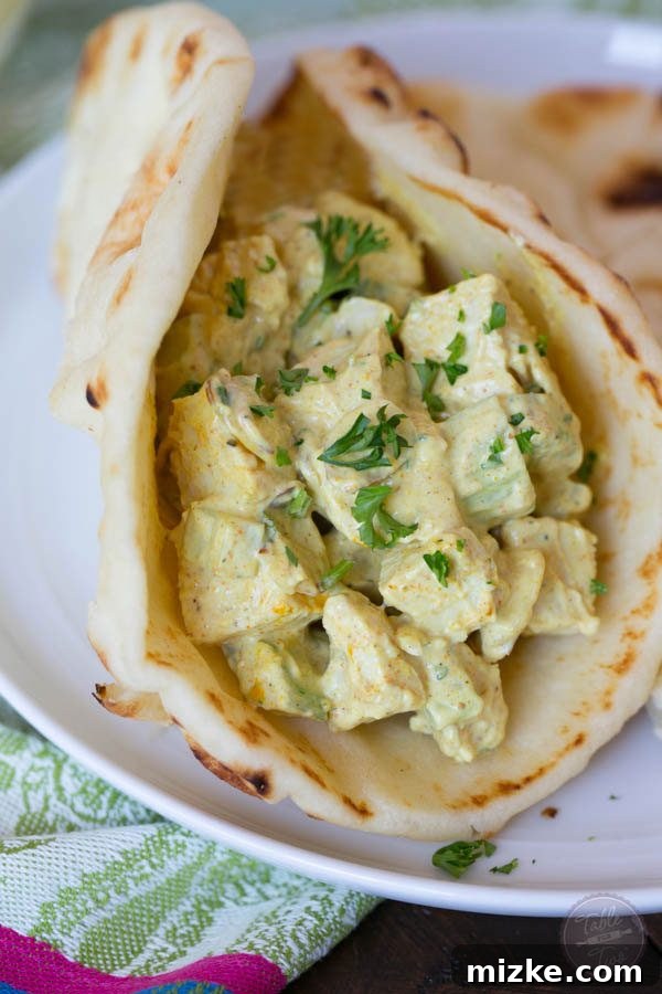 Golden Curry Chicken Salad 3 Close-up of a spoonful of creamy curry chicken salad, showcasing the diced chicken, celery, and rich golden hue from curry powder.
