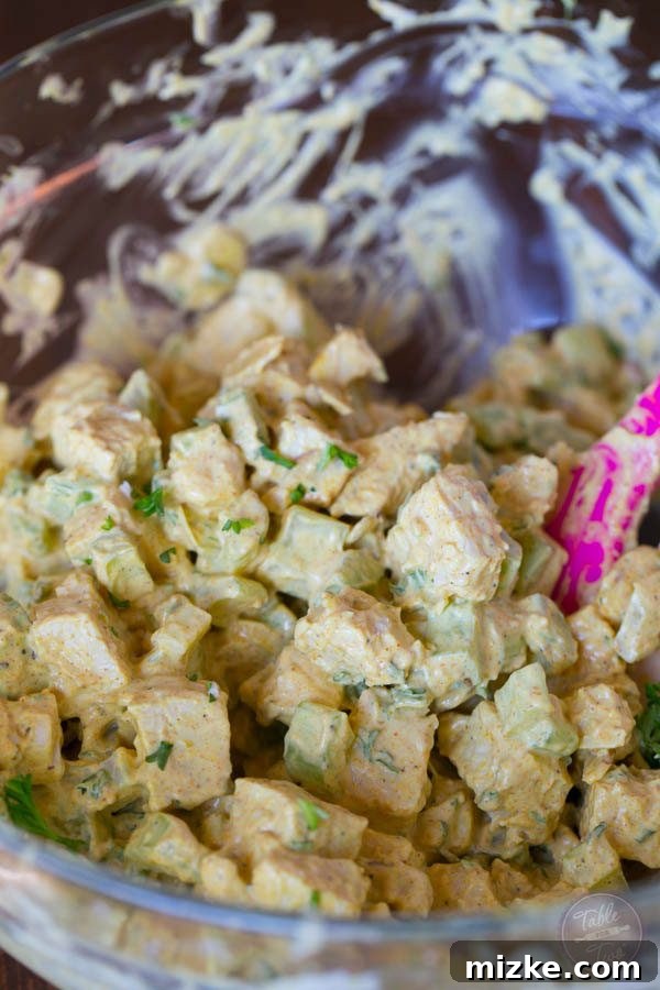 Golden Curry Chicken Salad 4 A serving of curry chicken salad nestled on a bed of fresh greens, ready to be enjoyed as a light and healthy meal.