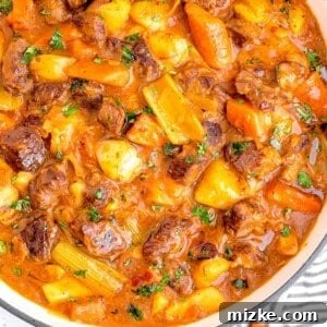 guinness beef stew in a white pot with a striped napkin next to it