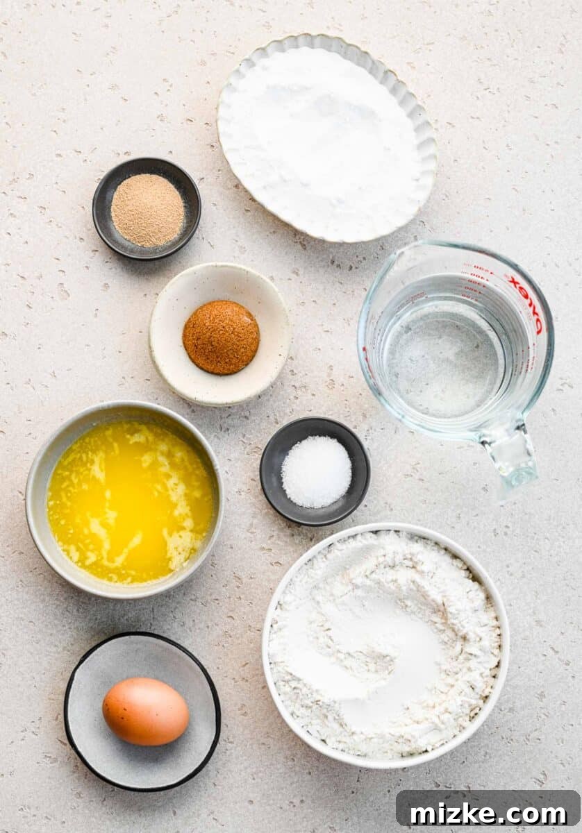 Various ingredients for making pretzel bites, neatly arranged in separate bowls on a kitchen counter.