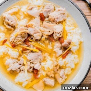A bowl of Drunken Chinese Chicken Soup with rice in a white bowl, looking inviting and delicious.