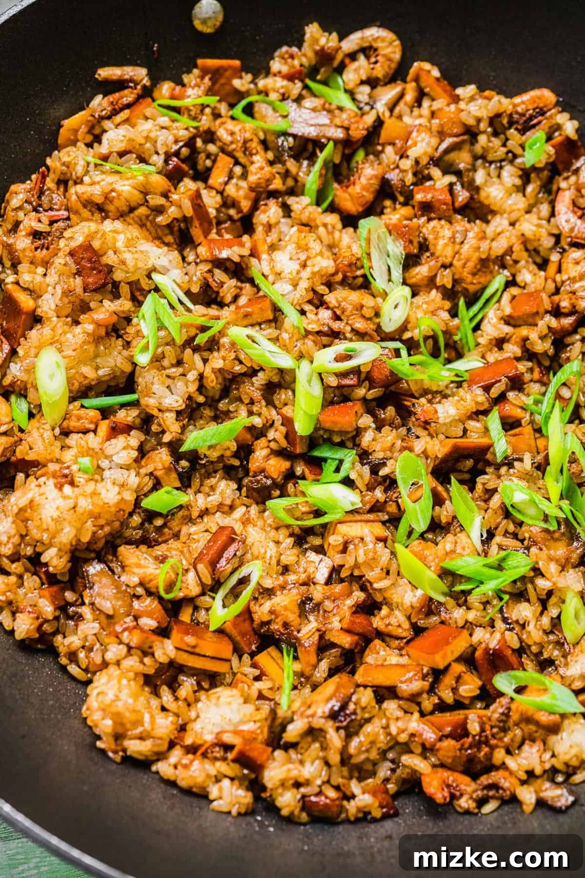 Skillet of sticky rice garnished with scallions