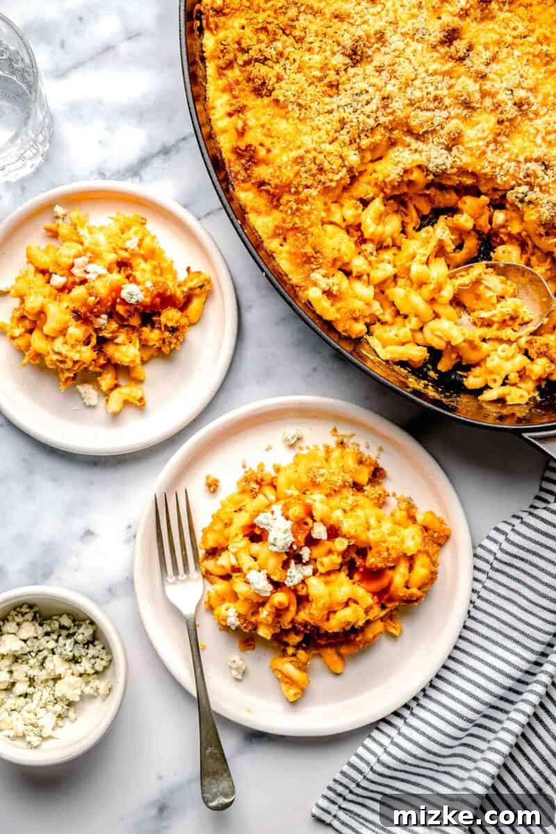 Kickin' Buffalo Mac and Cheese 9 Two individual servings of Buffalo Chicken Mac and Cheese with a full baking dish in the background, ready to be enjoyed.