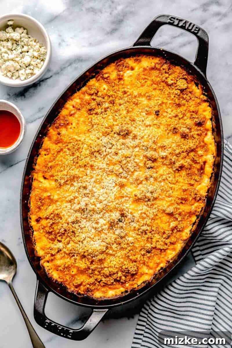 Kickin' Buffalo Mac and Cheese 10 A large, rustic baking dish is filled to the brim with perfectly baked Buffalo Chicken Mac and Cheese, showcasing its bubbly surface and golden crust.