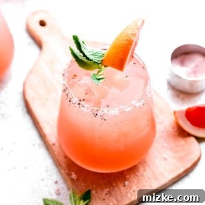A beautifully garnished Paloma cocktail, vibrant and ready to be served, perfect for a sunny day.