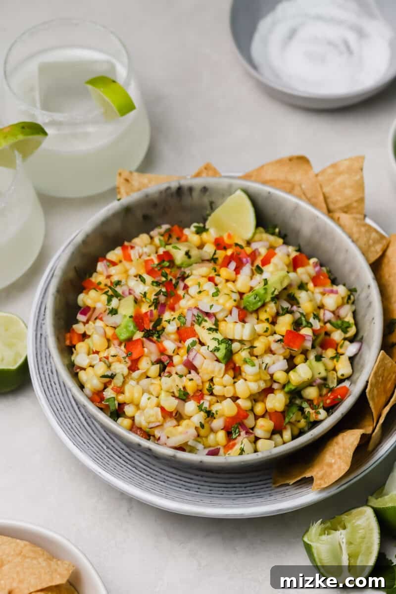 Zesty Corn and Avocado Salsa 4 A bowl of fresh corn and avocado salsa, garnished with fresh cilantro, resting on a rustic wooden table, ready to be enjoyed as a dip or a vibrant side.