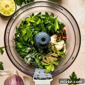 parsley, seasonings, and garlic in the bowl of a food processor