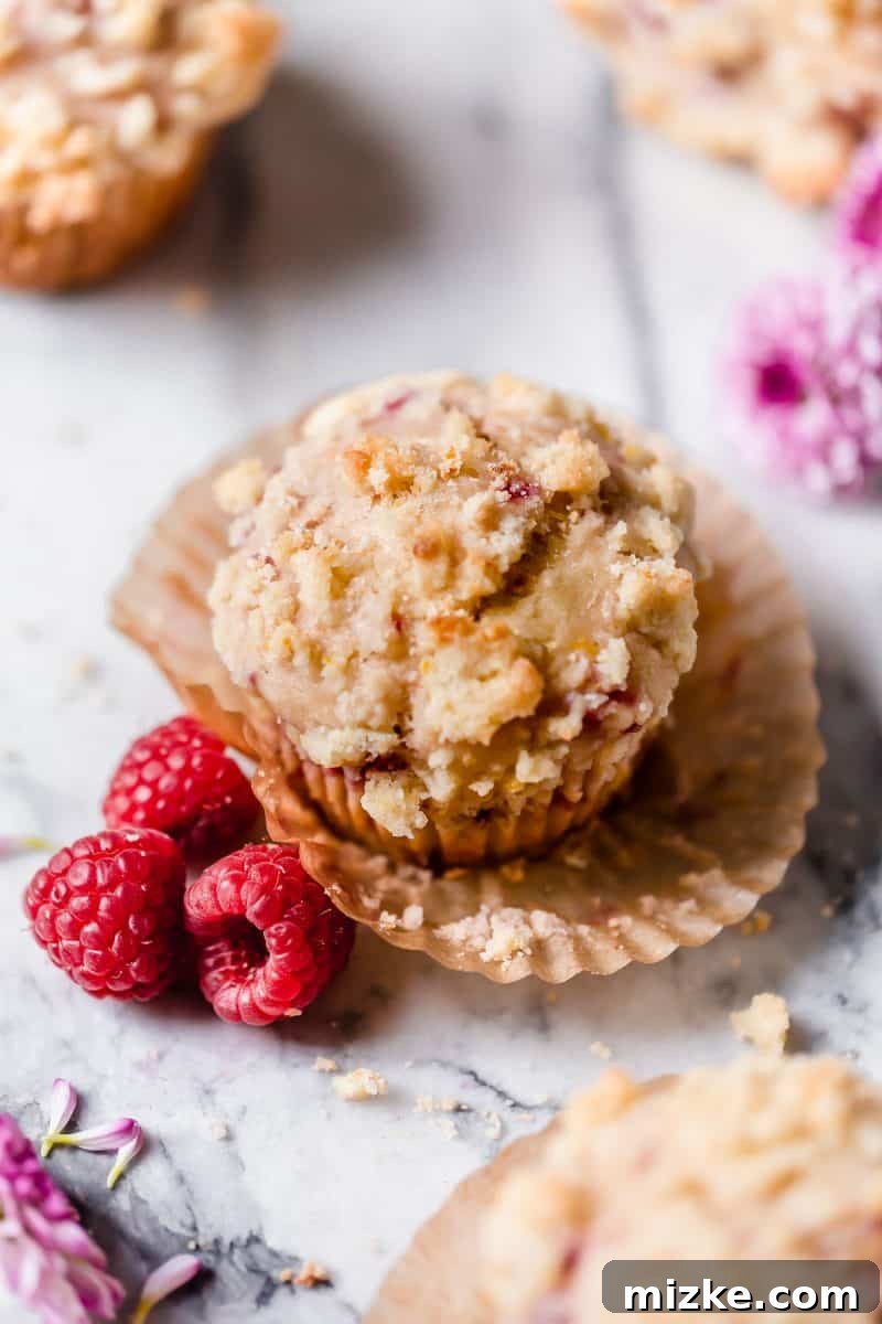 Zesty Lemon Raspberry Streusel Muffins 6 Several Raspberry Lemon Streusel Muffins arranged on a rustic wooden board, ready to be enjoyed.