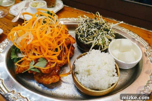Hearty family-style Korean catfish with rice and bean sprouts.