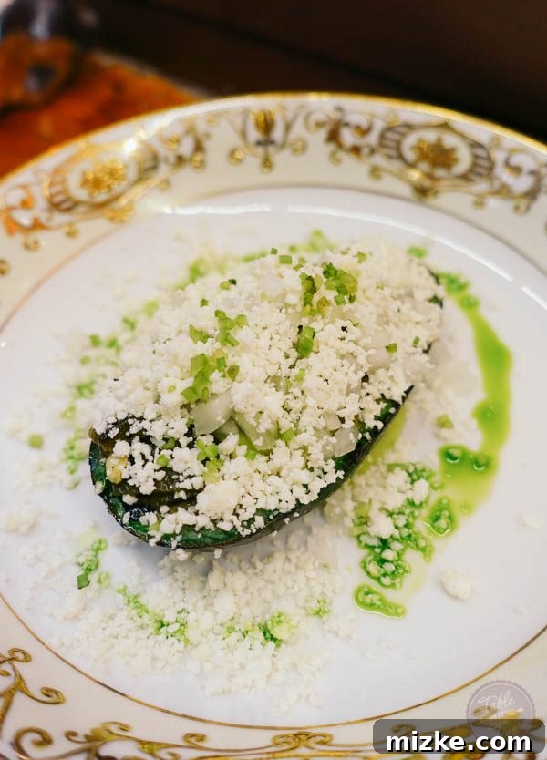 Unexpected grilled avocado dish with tomatillo and cotija cheese.