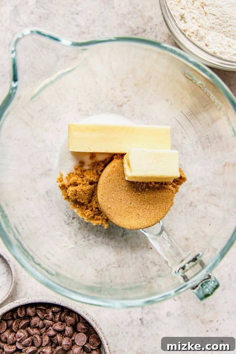 Combining softened unsalted butter with light brown sugar and granulated sugar in a stand mixer bowl.