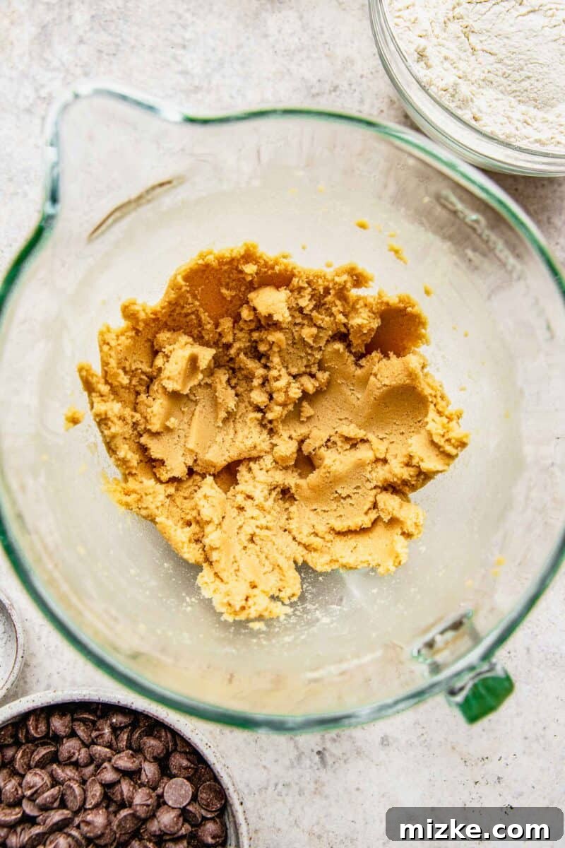 Close-up of perfectly creamed butter, brown sugar, and granulated sugar mixture, light and fluffy, in a mixing bowl.