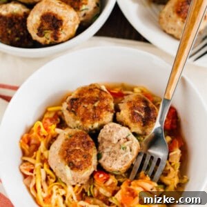 Delicious Zucchini Turkey Meatballs served over a bed of fresh zucchini noodles (zoodles) with sauce.