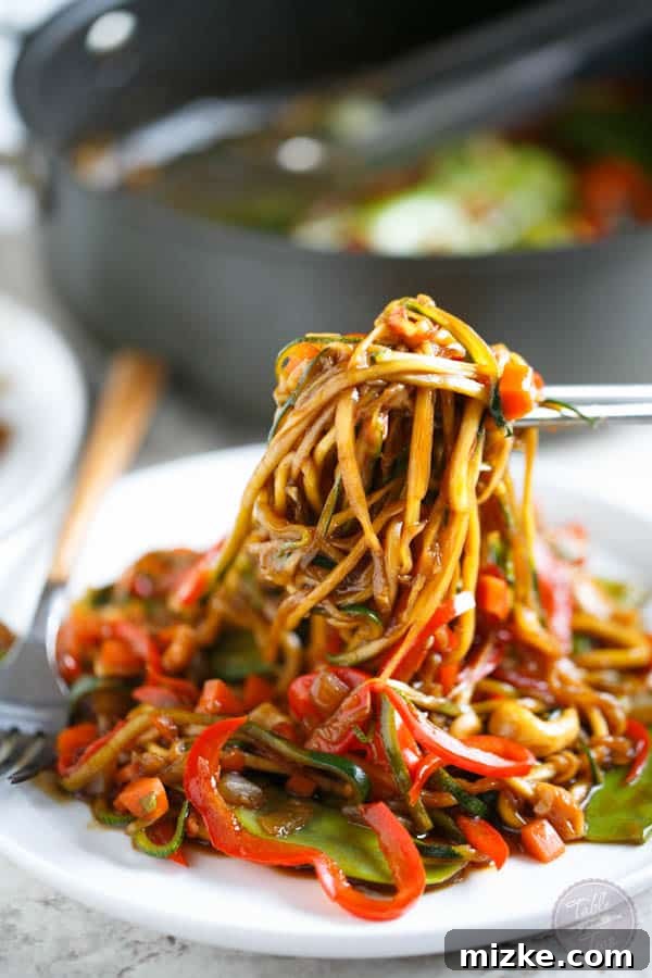 Vibrant Zoodle Cashew Stir Fry 3 A close-up shot of the vibrant Zucchini Noodle Cashew Stir Fry, highlighting the fresh spiralized vegetables and crunchy cashews.