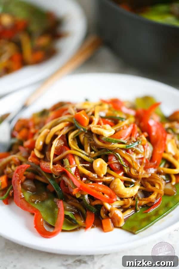 Vibrant Zoodle Cashew Stir Fry 5 The finished Zucchini Noodle Cashew Stir Fry in a bowl, garnished with extra cashews, ready to be enjoyed.