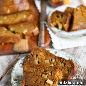 A close-up of a perfectly baked, golden-brown loaf of gluten-free Pumpkin Apple Bread, ready to be served.