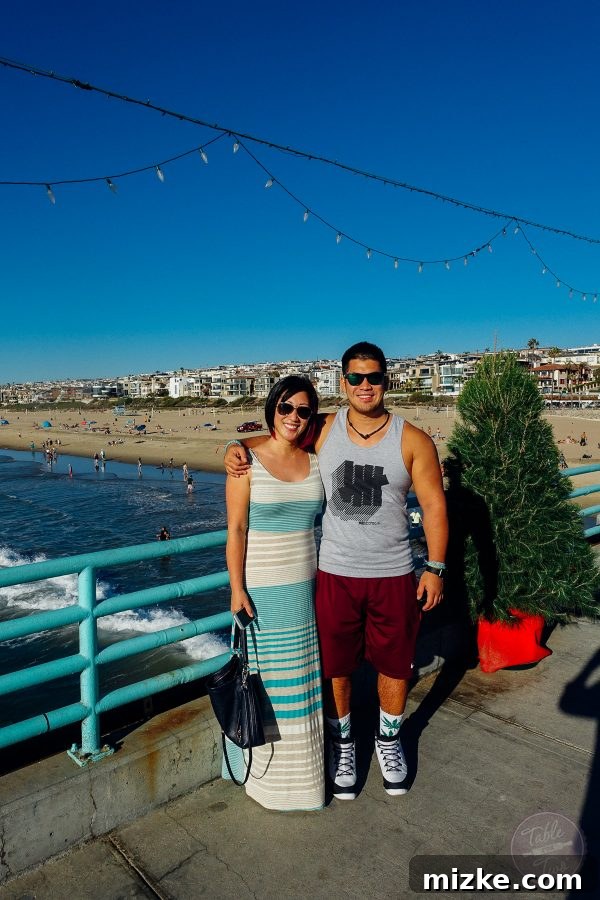 Palm trees swaying against a clear sky over Manhattan Beach, enhancing the tropical feel.
