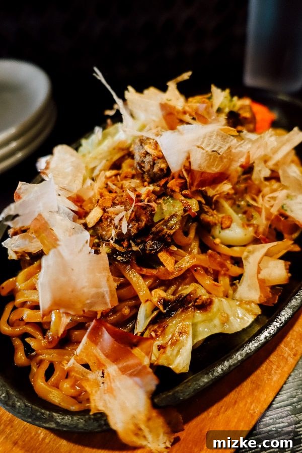 Delicious yakisoba dish topped with dancing bonito flakes and other fresh ingredients.