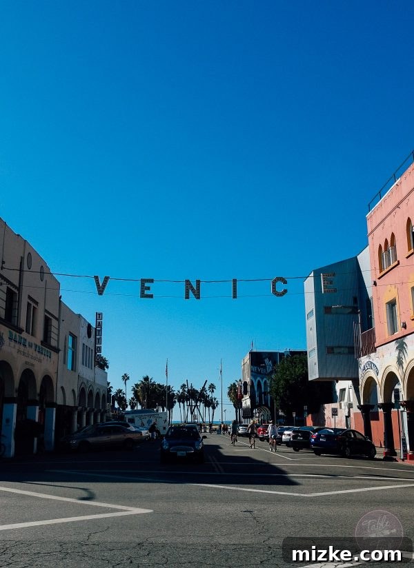 Vibrant Venice Beach boardwalk scene, bustling with unique characters and ocean views.