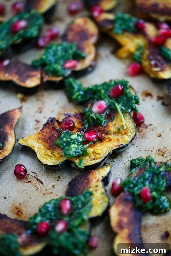 Golden Roasted Acorn Squash with Zesty Arugula Pesto and Pomegranate Gems 2 Vibrant roasted acorn squash with fresh arugula pesto and glistening pomegranate seeds, perfect for any festive table setting.