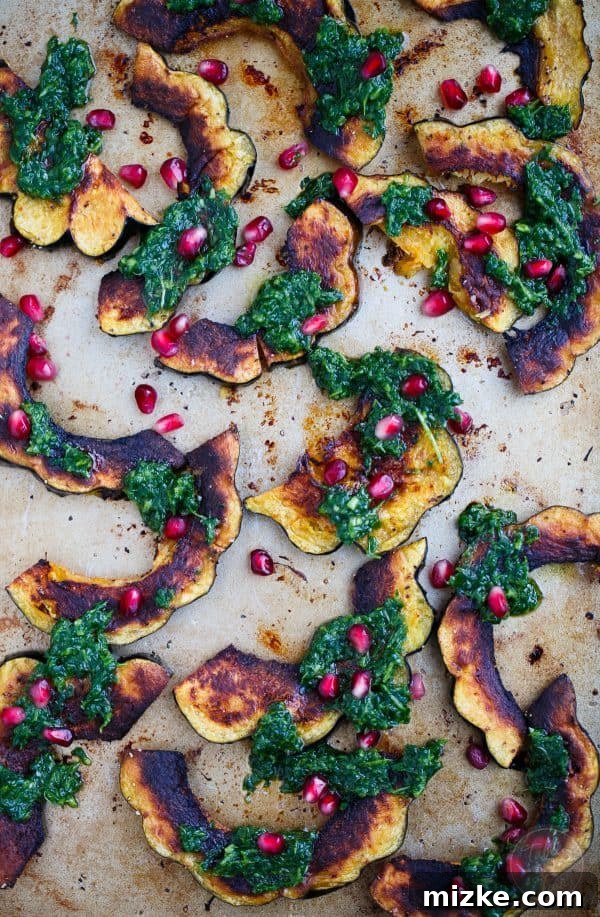 Golden Roasted Acorn Squash with Zesty Arugula Pesto and Pomegranate Gems 3 Close-up of roasted acorn squash slices, beautifully seasoned and ready for the flavorful arugula pesto and pomegranate topping.