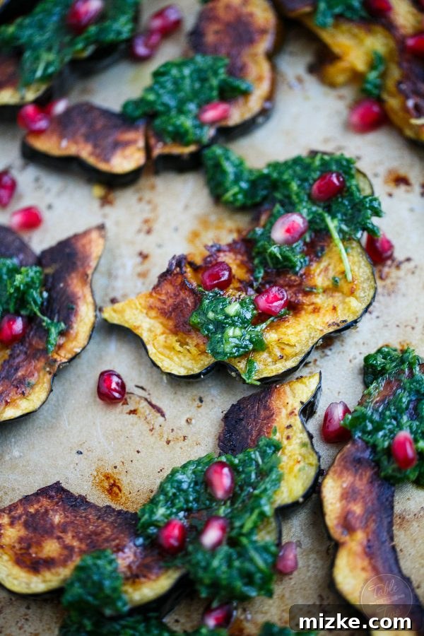 Golden Roasted Acorn Squash with Zesty Arugula Pesto and Pomegranate Gems 4 A festive platter of roasted acorn squash adorned with bright arugula pesto and jewel-like pomegranate seeds, ready to be served.
