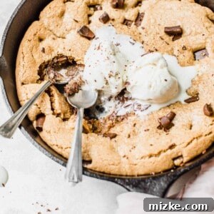 A beautifully golden-brown Skillet Coconut Chocolate Chunk Cookie, adorned with melted chocolate, ready to be enjoyed. Perfect for dessert lovers.