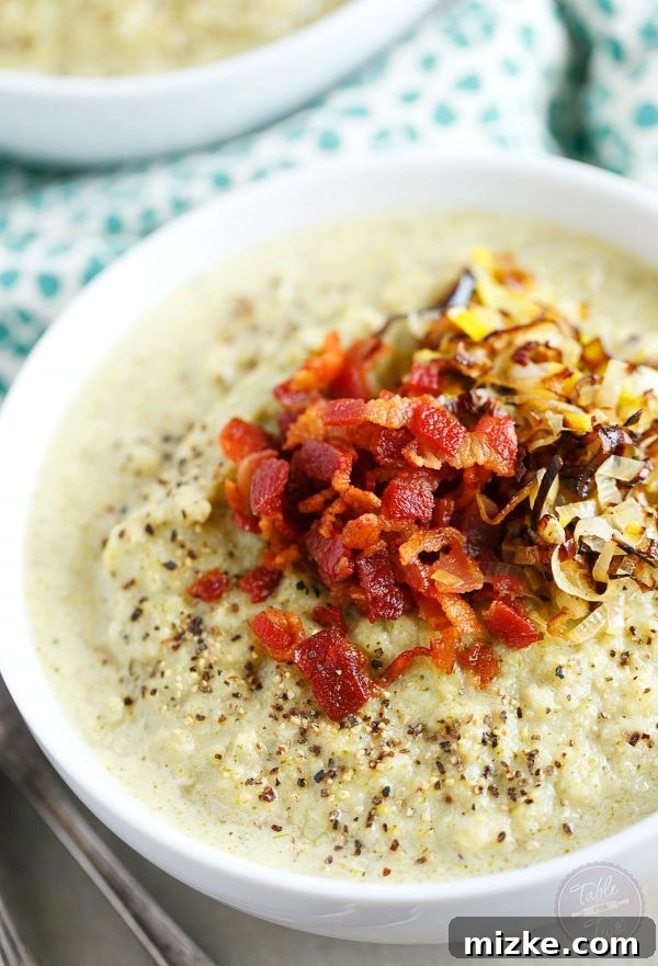 Velvety Roasted Broccoli and Cauliflower Soup with Savory Bacon Leek Crisps 4 A rustic cutting board features freshly chopped vibrant green broccoli and white cauliflower florets, perfectly prepared and ready for roasting. Alongside, a small bowl holds golden olive oil and aromatic garlic powder, highlighting the fresh, wholesome ingredients needed for this delicious soup.