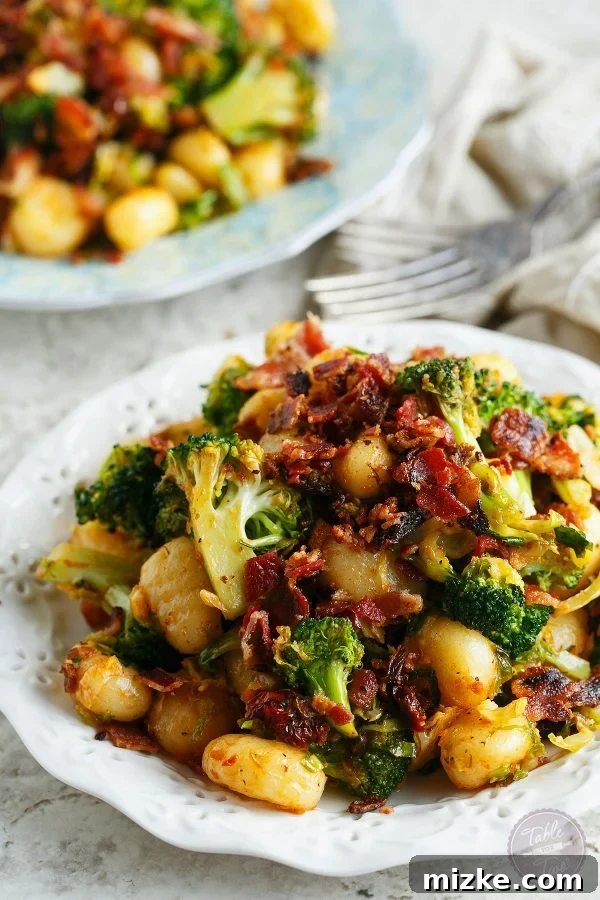 25-Minute Crispy Bacon Gnocchi with Roasted Broccoli & Shaved Brussels 4 A top-down view of a generous serving of bacon gnocchi with vibrant green broccoli and delicately shaved Brussels sprouts, ready to be enjoyed.