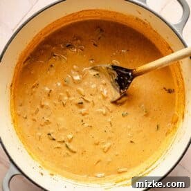Smoky Southwest Chicken Chili 7 A wooden spoon is in the center of a dutch oven with the chili mixture being stirred