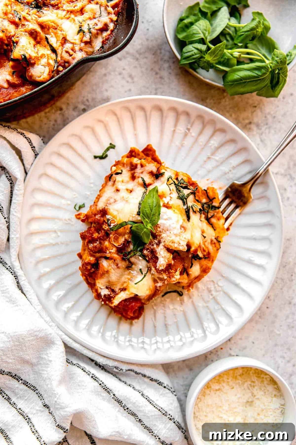 An overhead view of a serving of skillet lasagna on a plate, ready to be enjoyed.