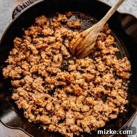 Browning Italian sausage in a skillet.