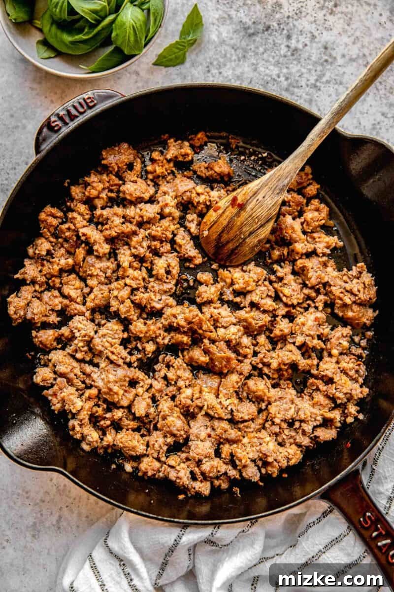 Browning Italian sausage in a skillet, breaking it up into crumbles.