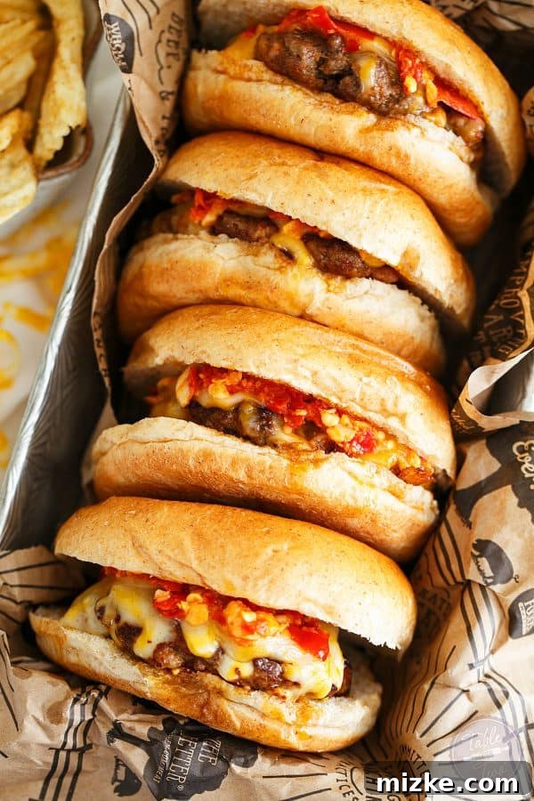 Three perfectly grilled Hot Pepper Garlic Chorizo Cheeseburgers arranged on a wooden board, showcasing their rich colors and enticing toppings.