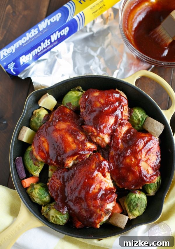 Easy BBQ Chicken and Vegetable Skillet 3 Close-up of juicy BBQ chicken and perfectly roasted carrots and potatoes in a cast iron skillet, ready to be served.