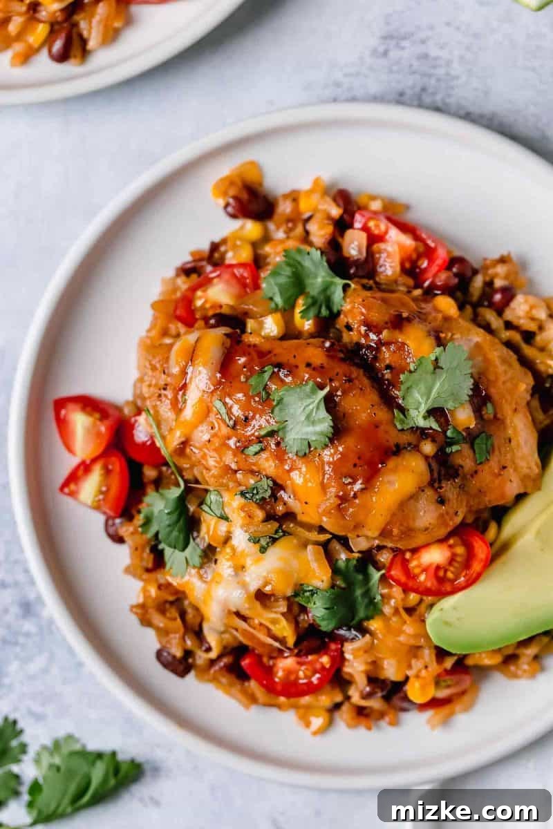 This one-pot BBQ chicken and rice is a weeknight meal saver! It is loaded with flavor and it's basically like having your favorite BBQ restaurant chicken and rice dish at home! The finished one-pot BBQ chicken and rice, topped generously with melted cheese.