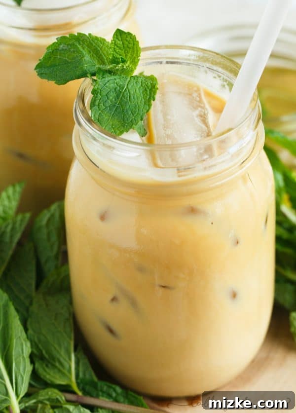 Mint Chill Latte 2 A refreshing Iced Mint Latte served in a glass, garnished with fresh mint leaves, set against a bright, inviting background. Perfect for coffee and mint enthusiasts.