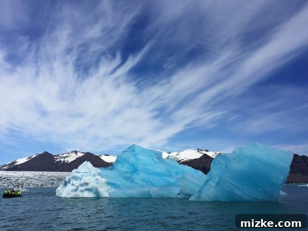 Iceland's Glacial Jewel: A 5-Day Jökulsárlón Exploration 16 Another large iceberg with a Zodiac tour boat for scale, Jökulsárlón