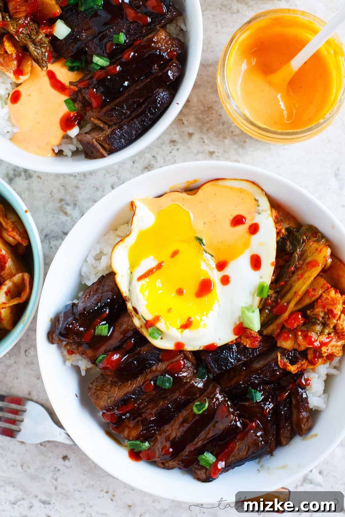 Irresistible Korean Galbi Bowls 4 A vibrant Korean Galbi Bowl ready to be enjoyed, topped with a runny fried egg and kimchi.