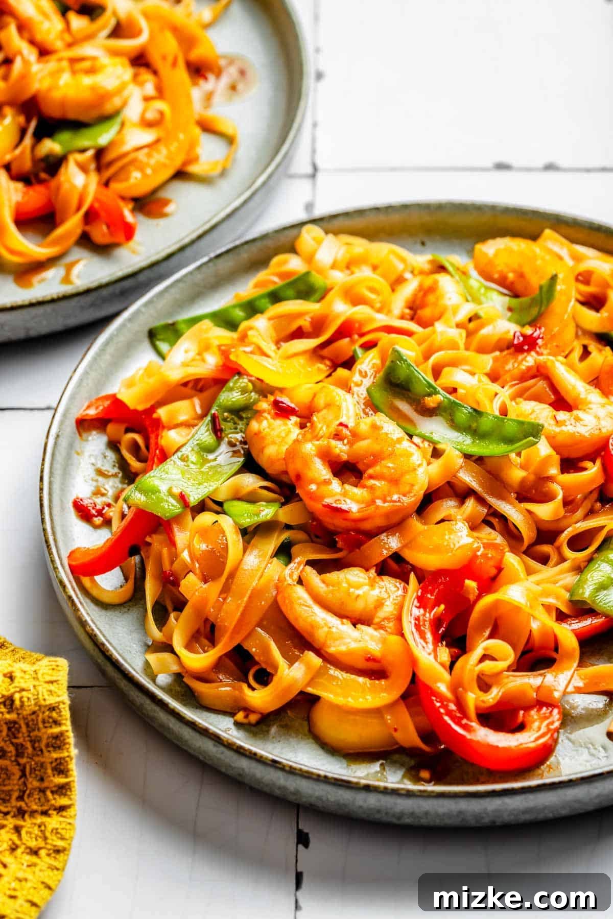 Sizzling Shrimp Noodle Delight 3 shrimp noodle stir fry on a rimmed plate