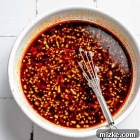 Sizzling Shrimp Noodle Delight 4 ingredients for shrimp stir fry sauce in a bowl with a small metal whisk